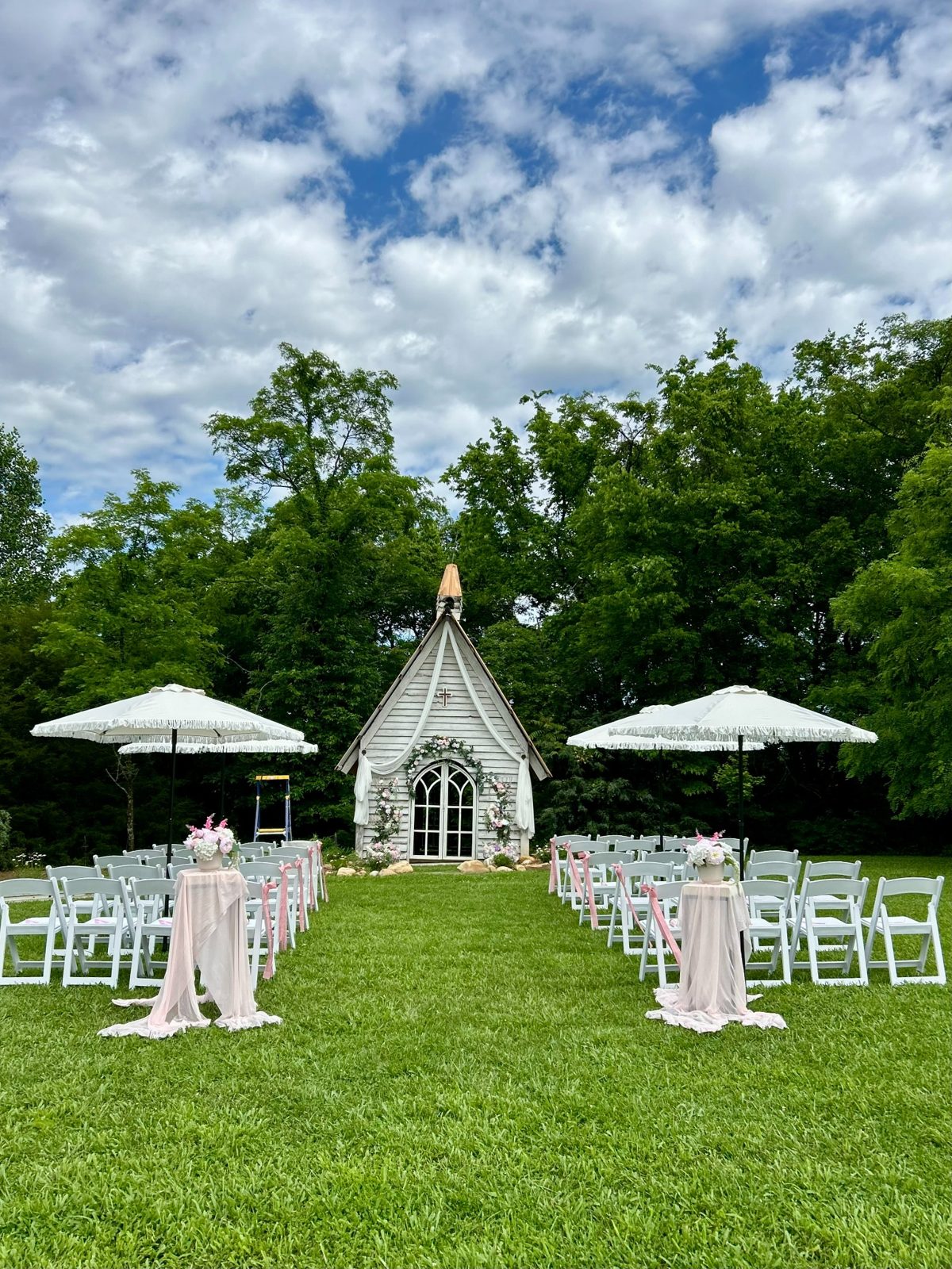 Outdoor chapel aisle with parasols and blush accents